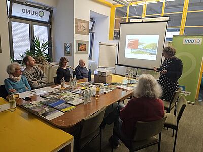Frau Prof. Dr. Diana Pretzell an der Präsentationsleinwand, fünf Zuhörende im Publikum
