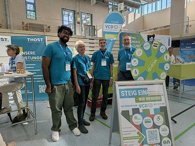 Vier VCD-Aktive posieren vor dem Infostand für ein Gruppenfoto.