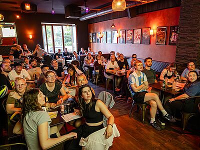Die Rateteams blicken gespannt auf die Leinwand