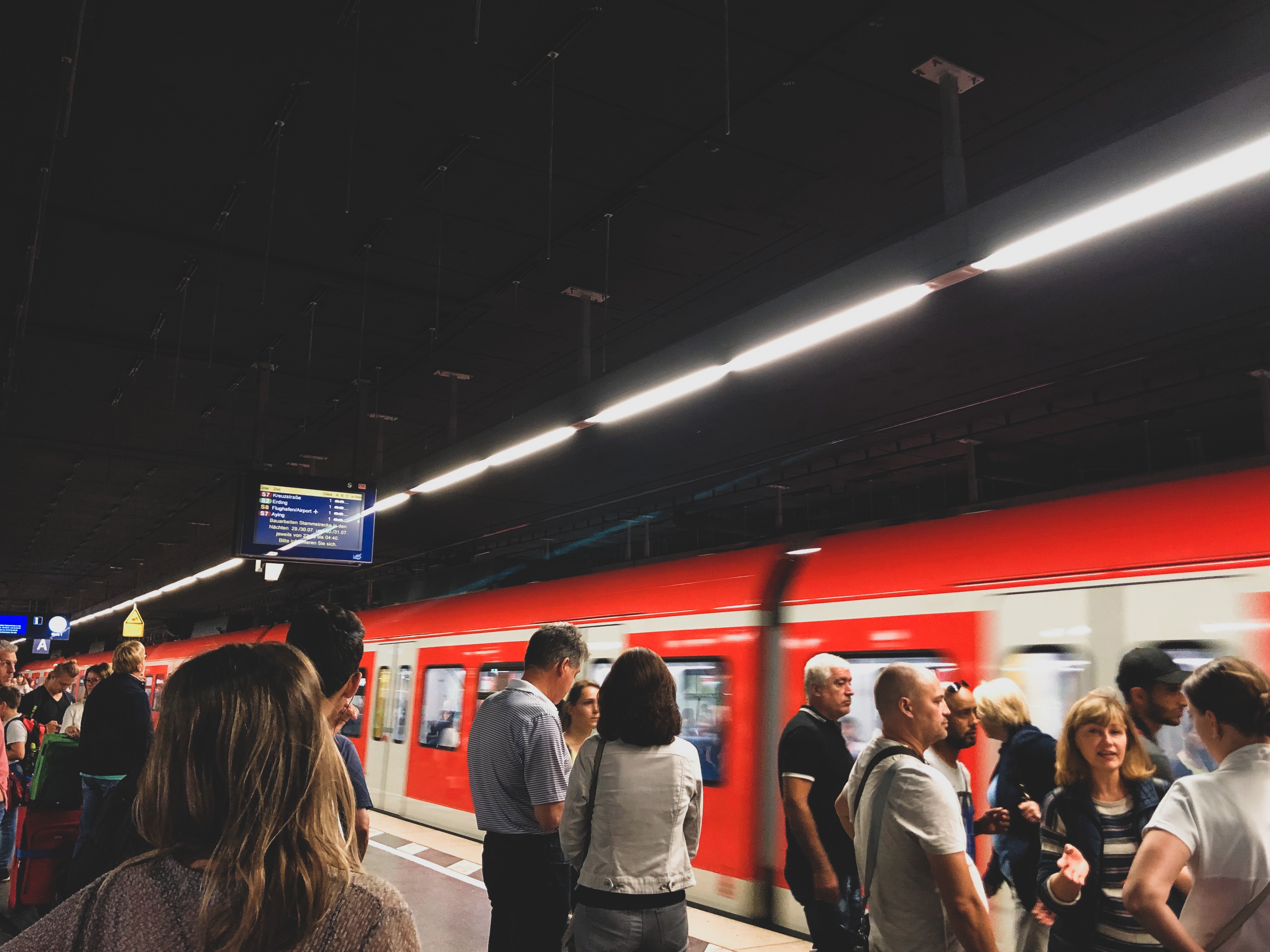 Im Vordergrund Menschen am Bahnsteig im Hintergrund S-Bahn in Bewegung