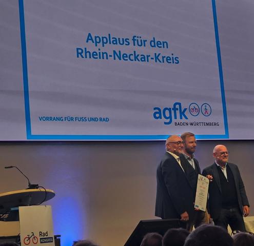 AGFK-Vorsitzender Günter Riemer und Verkehrsminister Winfired Hermann übergeben die Urkunde an einen Vertreter des Rhein-Neckar-Kreises