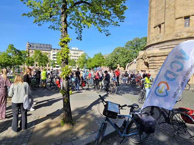 Aufstellung der Teilnehmenden an der Raddemo beim Mannheimer Wasserturm. Im Vordergrund Fahrrad mit großer VCD-Fahne.